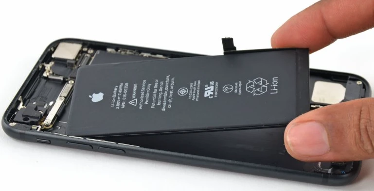 battery replacement A person removing an iPhone battery to inspect its condition, illustrating the step to check battery health and usage in iPhone 14.