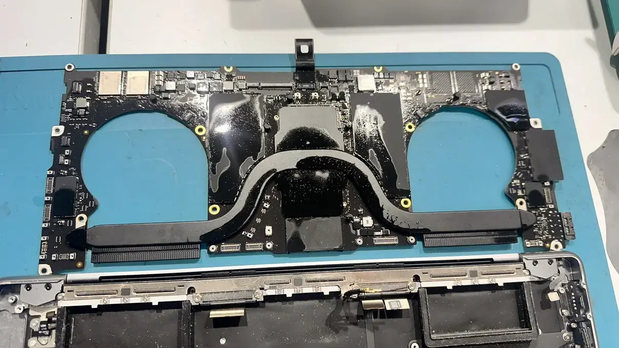 Case Study: MacBook Pro A2442 Liquid Damage Repair: From Dead to Perfect 2 MacBook logic board removed from chassis, showing heat pipes and corrosion during Stage 1 of the component analysis and repair process.