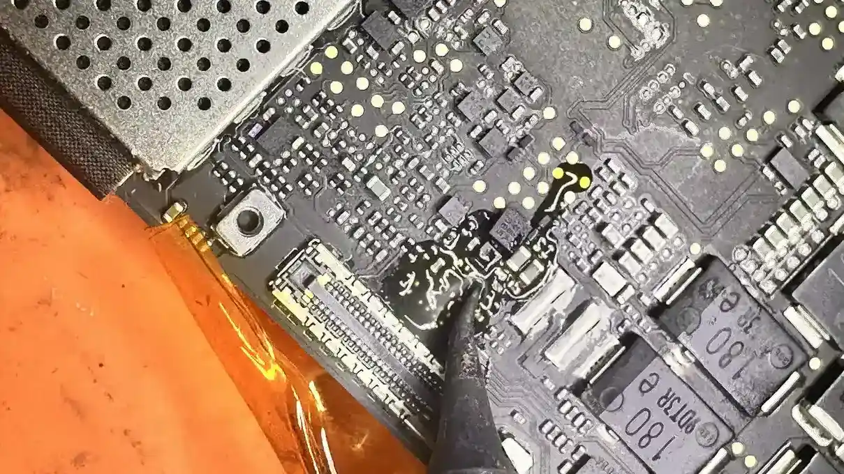 Case Study: MacBook Pro A2442 Liquid Damage Repair: From Dead to Perfect 1 Close-up of a MacBook Pro logic board showing corrosion and burn marks during the initial assessment of a liquid damage repair.
