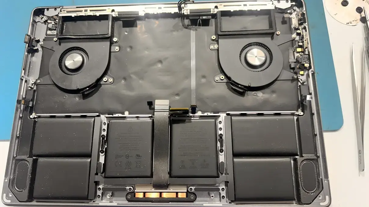 Case Study: MacBook Pro A2442 Liquid Damage Repair: From Dead to Perfect 3 Interior of a MacBook Pro during Stage 2 post-repair testing, showing cooling fans, battery cells, and internal components reassembled.